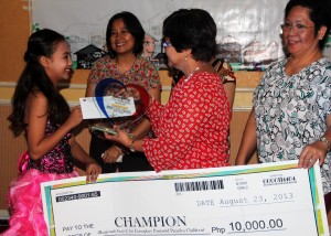 Shemia Pineda (Left), winner of the Regional Search for Exemplary Pantawid Pamilya Children, smiles at RD Naviamos as she receives her plaque and Php 10,000 cash prize. 