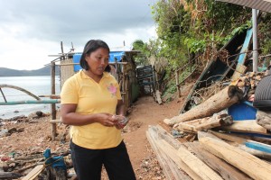 Annabelle stares at some of the materials left from their home when typhoon Yolanda made its landfall in Coron, Palawan.