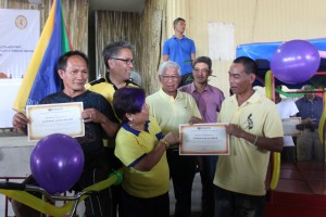 Secretaries Dinky Soliman (DSWD), Mar Roxas (DILG) and Voltaire Gazmin (DND) hand certificates to recipients of 'pedicabs' for livelihood assets to two of 13 beneficiaries during the commemoration of Yolanda, in Coron, Palawan.