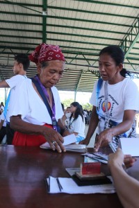 A fellow partner-beneficiary helps an elder Mangyan in getting her cash grant during the Pantawid Pamilya payout in San Teodoro, Oriental Mindoro.