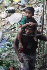 A Mangyan father carries the little son on his back. 